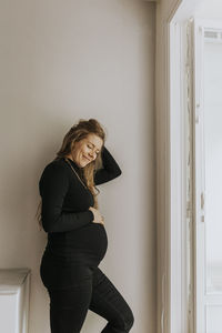 Smiling pregnant woman at home