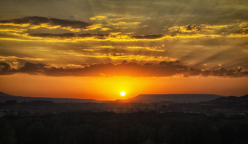 Silhouette of landscape against cloudy sky