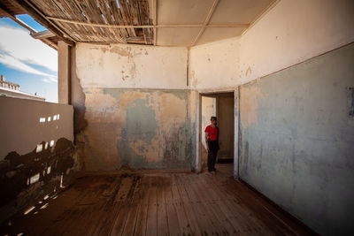 Rear view of man standing in abandoned building