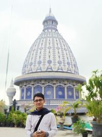 Portrait of a buddha statue against building