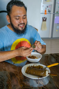 Man holding ice cream on table at home