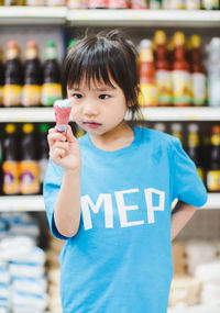 Close-up of cute girl eating ice cream cone in store