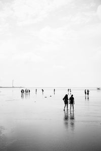 People on beach against sky