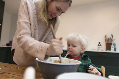 Mother feeding boy at home