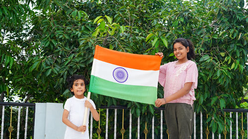 Two indian child celebrating independence or republic day, cute little indian child holding, waving 
