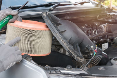 Cropped image of hands holding tool on vehicle