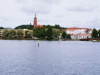 Buildings in city against cloudy sky