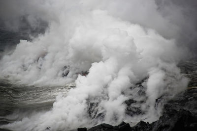 Lava flow into the ocean, with steam and haze