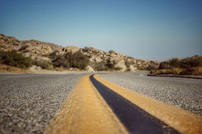 Surface level of road against clear sky