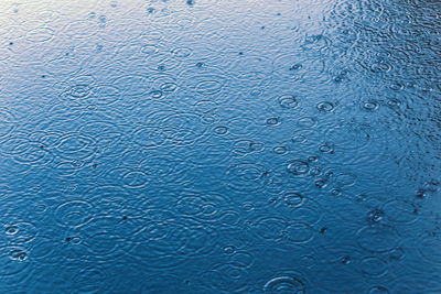 Full frame shot of raindrops on puddle