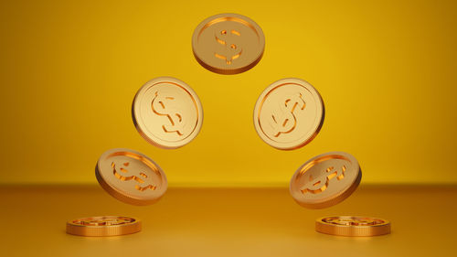 Close-up of clock on table against yellow background