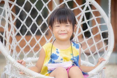 Portrait of smiling girl sitting outdoors