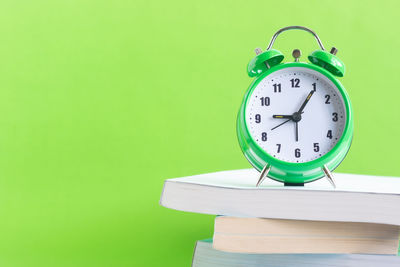 Close-up of clock on table against wall