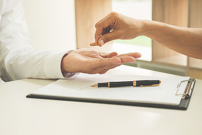 Close-up of couple signing divorce document 