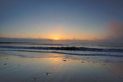 Scenic view of beach against sky during sunset