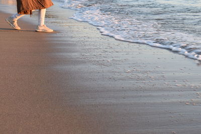 Low section of woman standing on beach