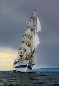 Sailboat sailing in sea against sky