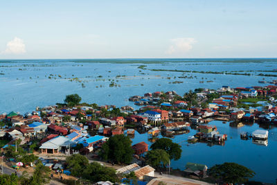 High angle view of houses by sea against sky