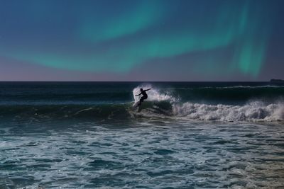 Man surfing in sea against sky