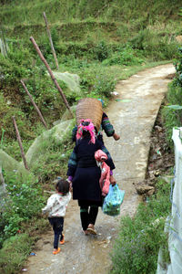 Rear view of people walking footpath