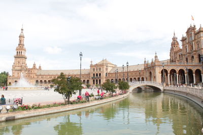 Arch bridge over river against buildings in city