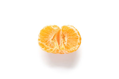 Close-up of orange slice over white background