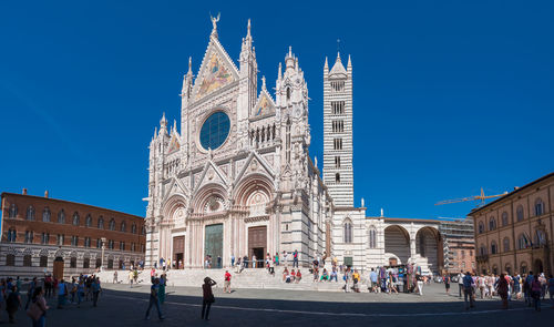 Siena town square with tourists and cathedral, siena duomo. panorama image