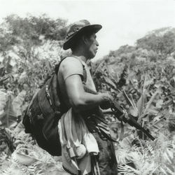 Side view of young man holding hat on field