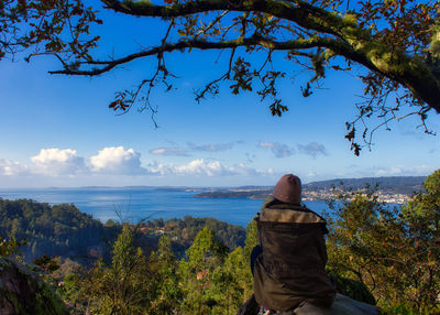 Rear view of woman looking at view of mountain against sky