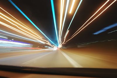 Light trails on road in illuminated tunnel