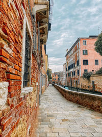 Narrow alley amidst buildings against sky