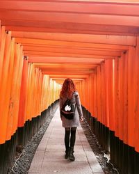 Rear view of woman standing on footpath