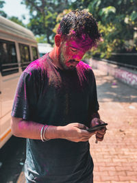 Portrait shot of man using mobile phone, after holi 