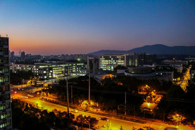 High angle view of illuminated cityscape against sky at dusk