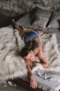 Rear view of naked man lying down on fur