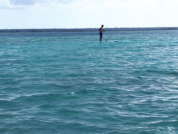 Man surfing in sea against sky