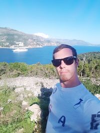 Portrait of young man in sunglasses against sea