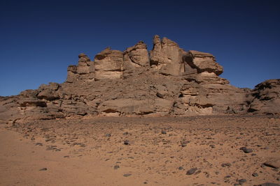 Scenic view of rocky mountains against clear sky acacus moutain, libya