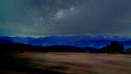 Scenic view of snow covered mountains at night