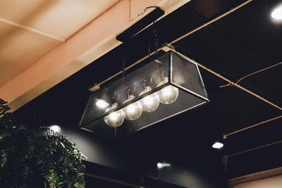 Low angle view of illuminated pendant lights hanging from ceiling