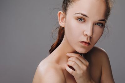 Portrait of shirtless woman against gray background