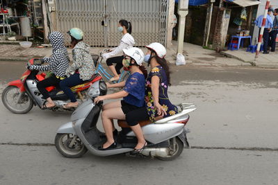 People riding motorcycle on road