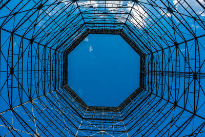 Directly below shot of modern building against clear blue sky