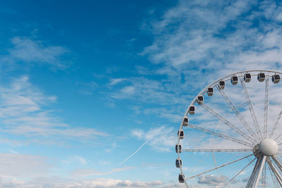 Low angle view of ferris wheel against blue sky