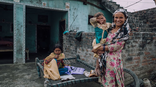 Happy girl smiling while standing against built structure