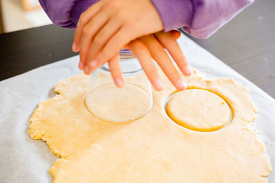 Cropped hand of person preparing food on table