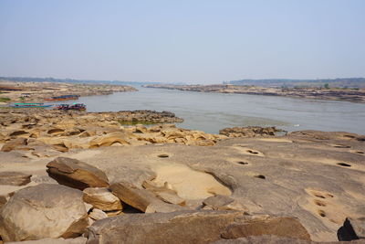 Rocks on beach against clear sky