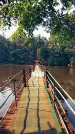 Footbridge over river against sky