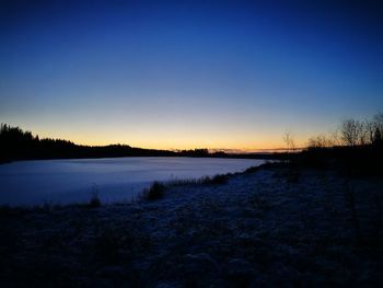 Scenic view of lake against sky at sunset