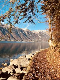 Scenic view of lake by mountains against sky